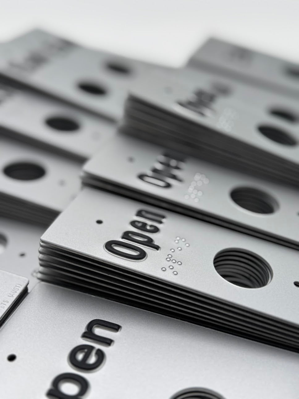 Stacks of silver 'Open' braille signs.