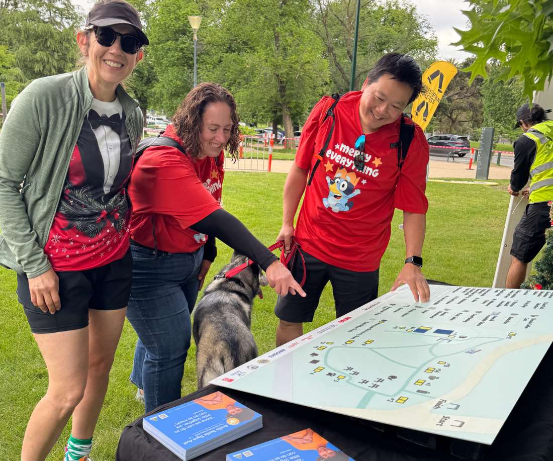 Group of people in a park, using a braille tactile map.
