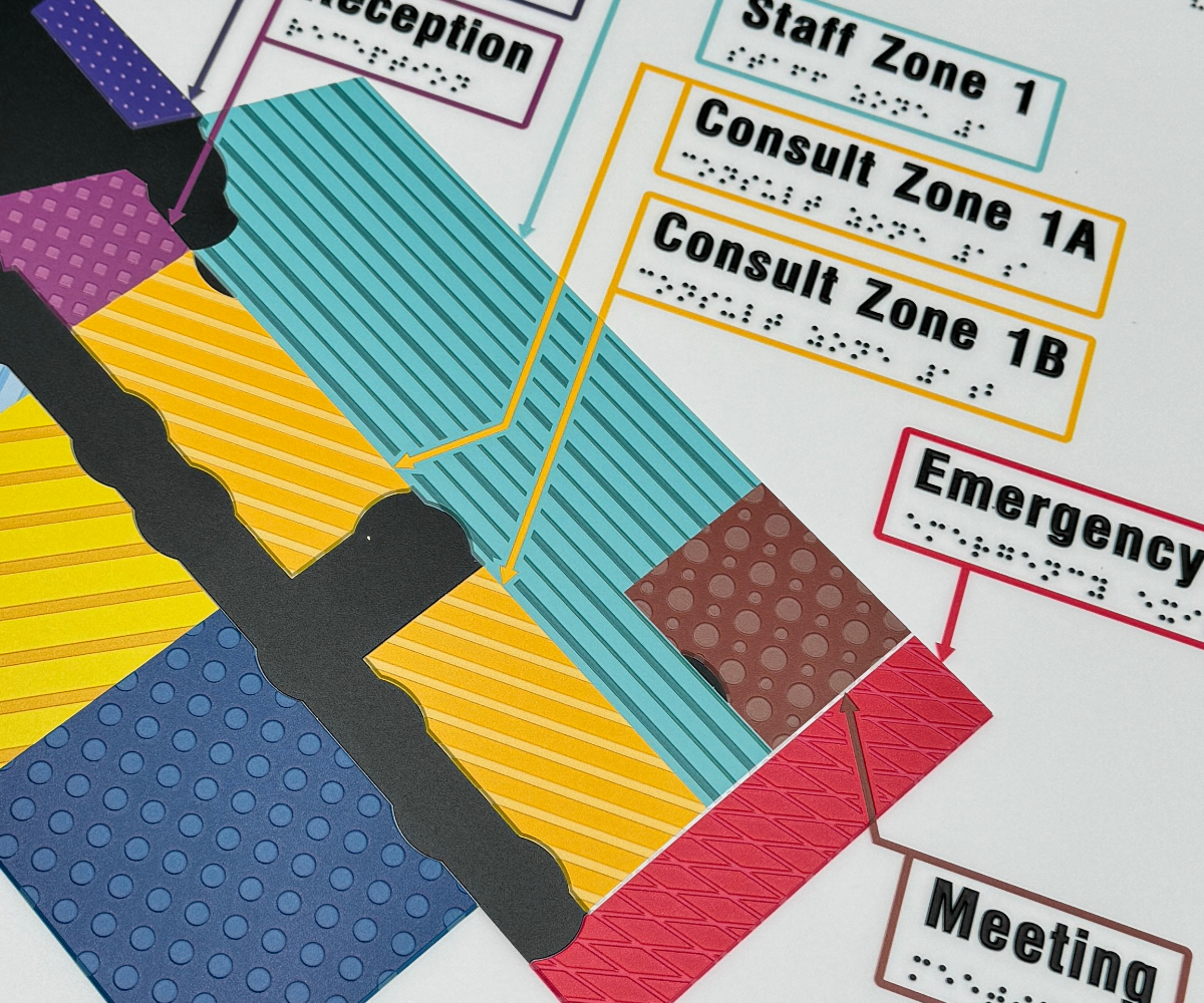 Colourful braille tactile map, with consult zones, receeption, staff zone and meeting space.