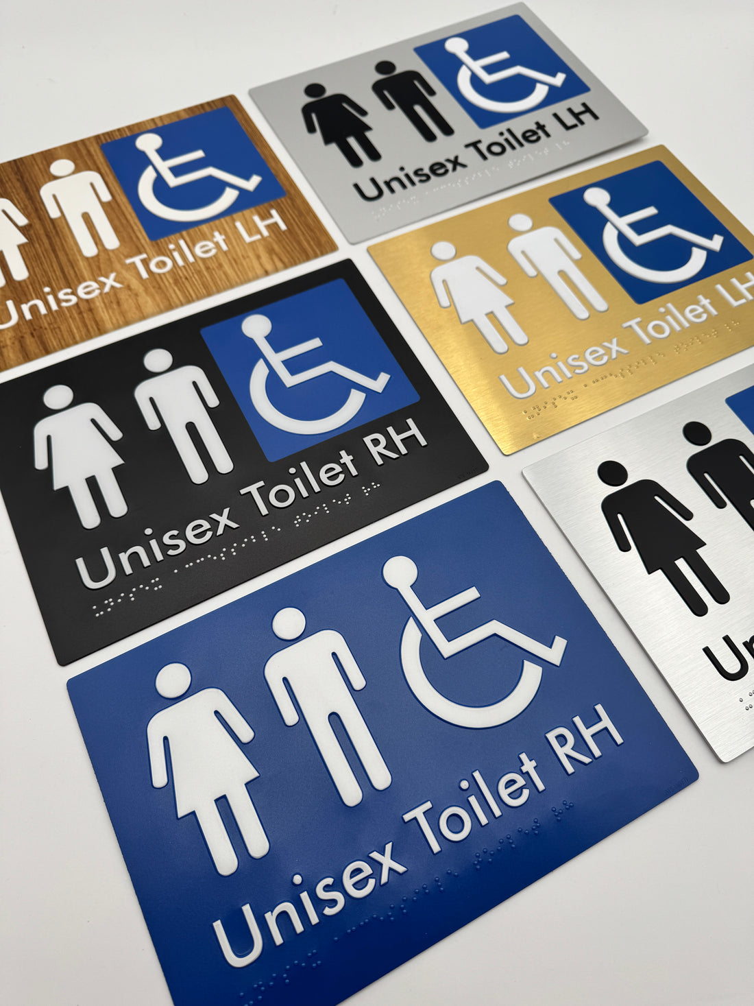 Collection of unisex and disabled toilet braille signs on a white background