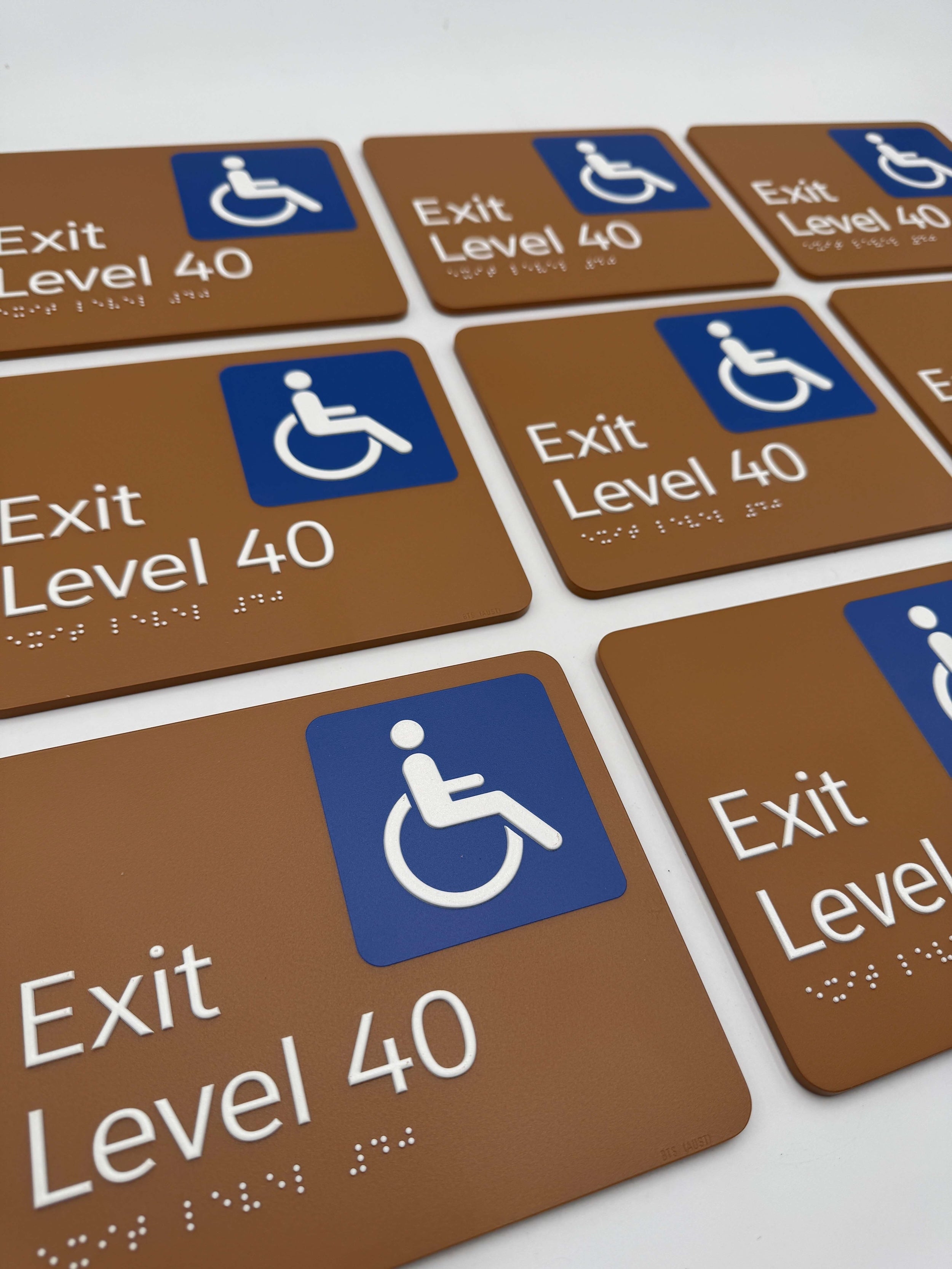Numerous brown exit level 40 signs, with an accessible icon and white braille text.