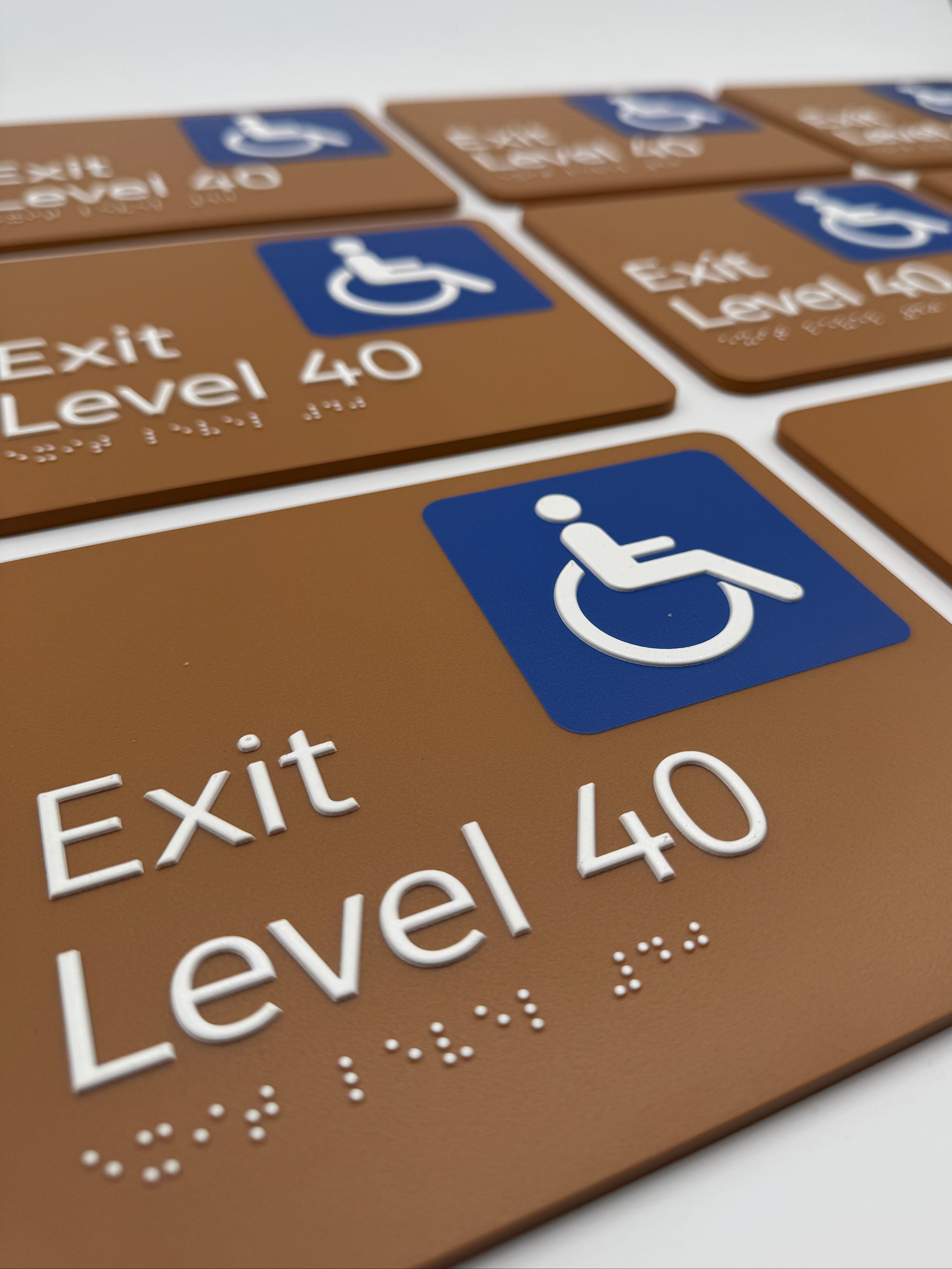 Multiple 'Exit Level 40' brown braille signs with wheelchair accessibility symbol.