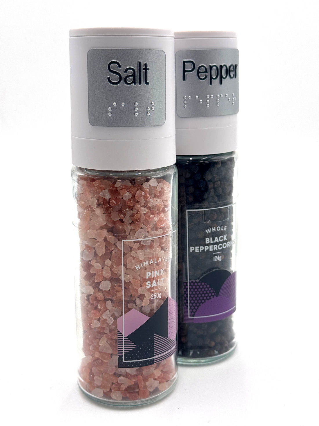 Two salt and pepper shakers with braille labels on the lids.