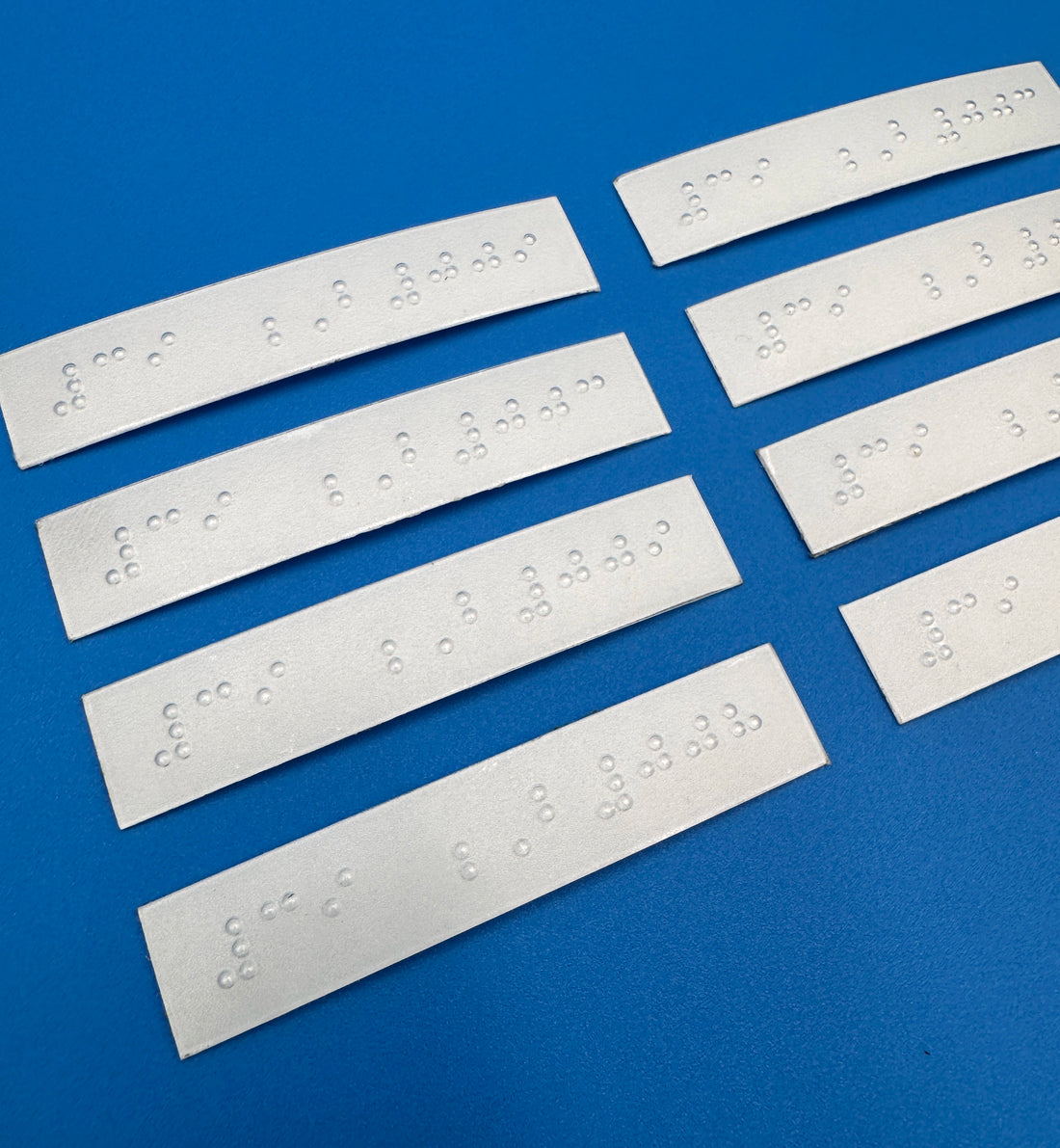 Set of silver braille strips on a blue background.