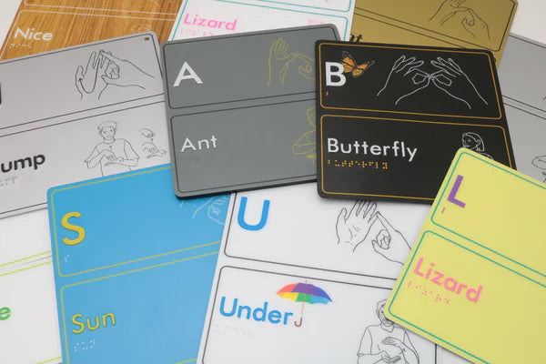 Educational braille signage with letters and AUSLAN hand illustrations.